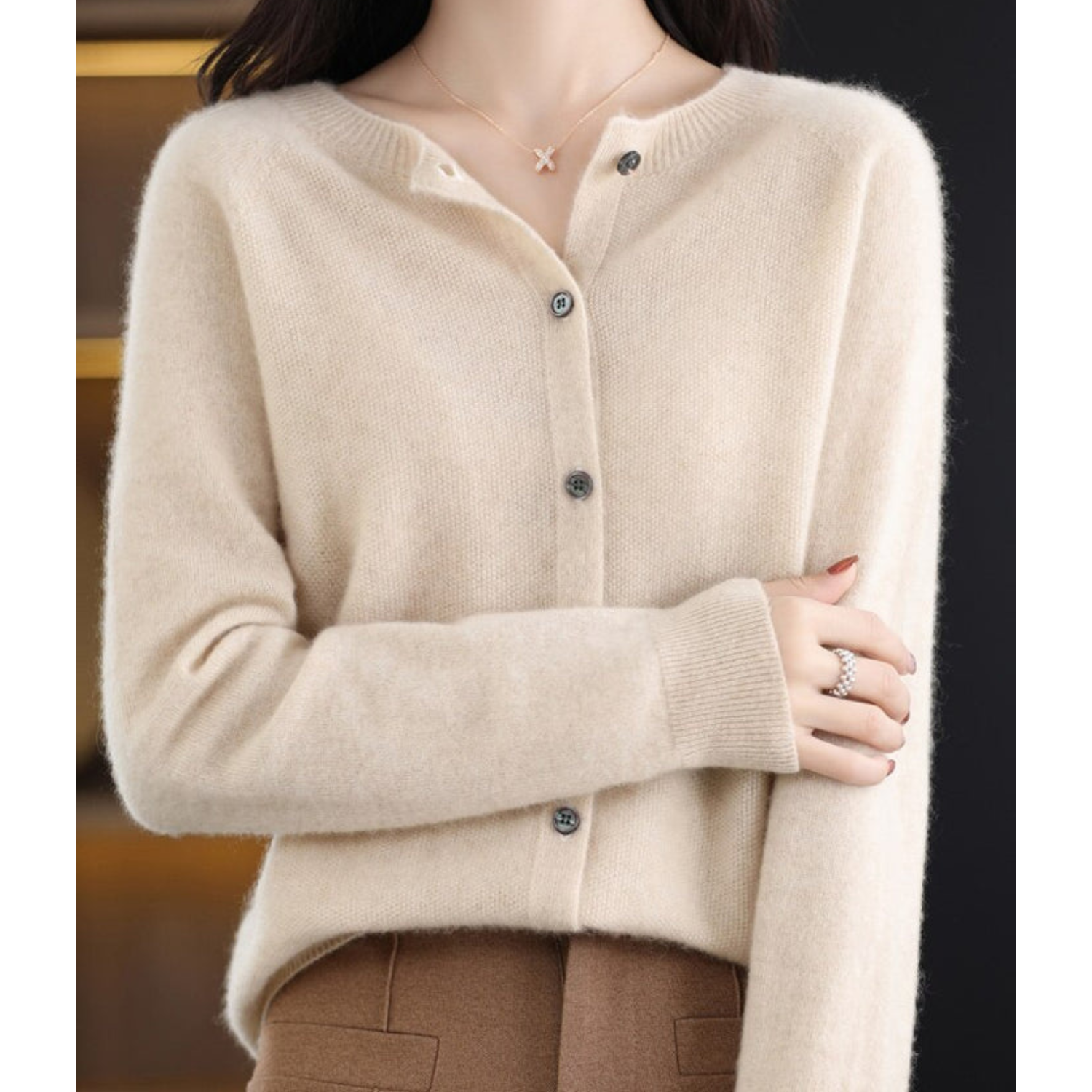 Beige cardigan i cashmere med knapper, båret af kvinde. Elegant og stilfuldt design, perfekt til efterårsmode. Komfortabelt og luksuriøst tøjvalg.