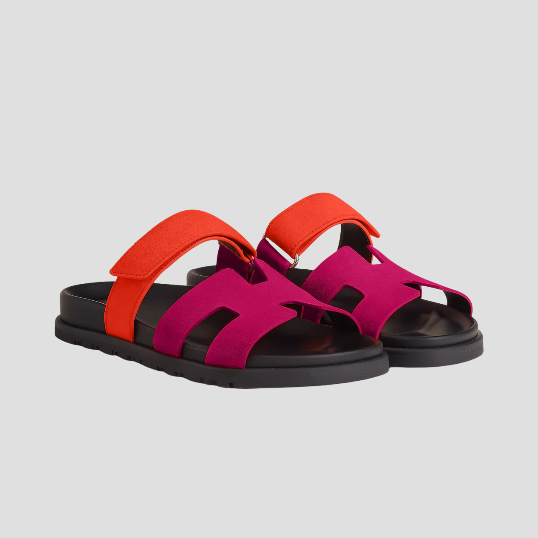 Røde og pink lædersandaler med flade såler og brede stropper, moderne design, komfortabelt fodtøj til sommerbrug.