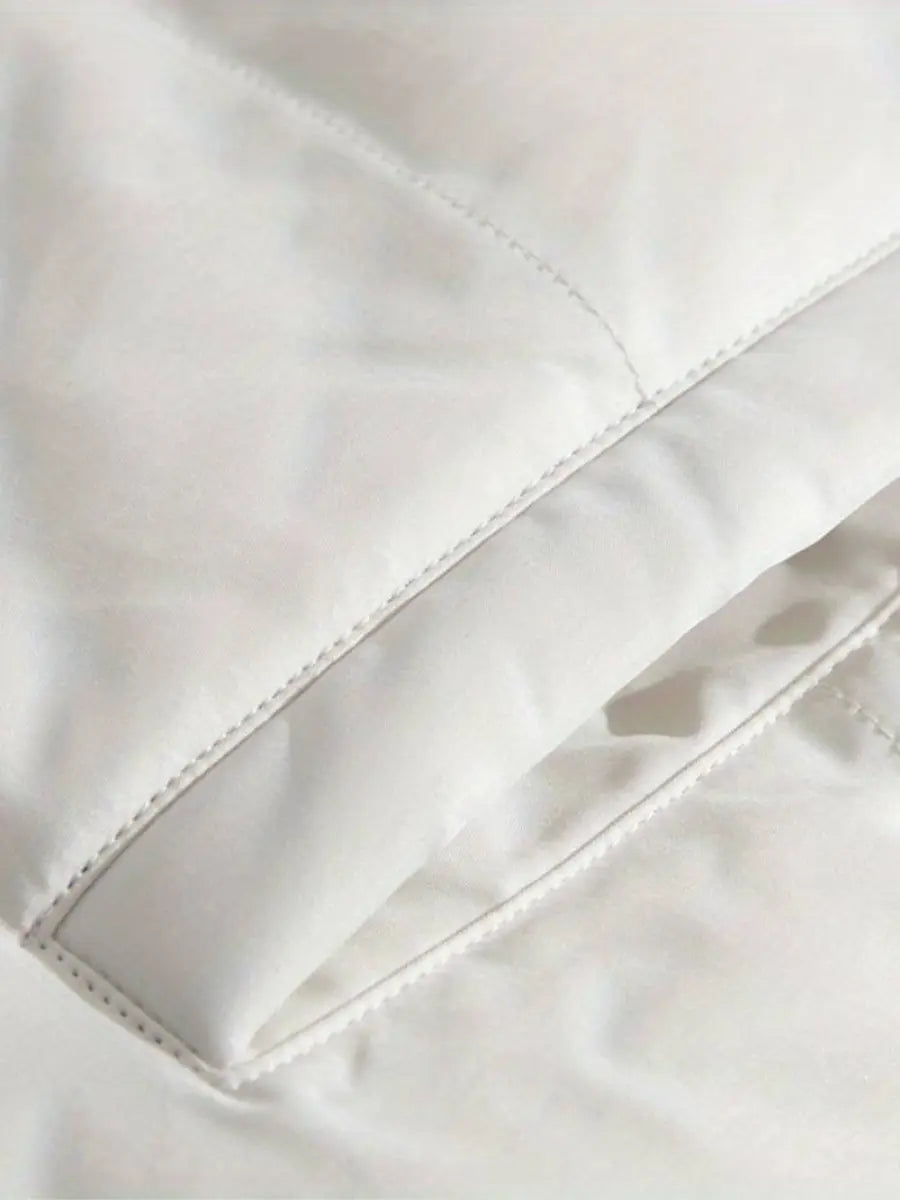 Hvid dyne med syninger, blød tekstur og minimalistisk design. Perfekt til soveværelset for komfort og stil. Ideel til vinterbrug.