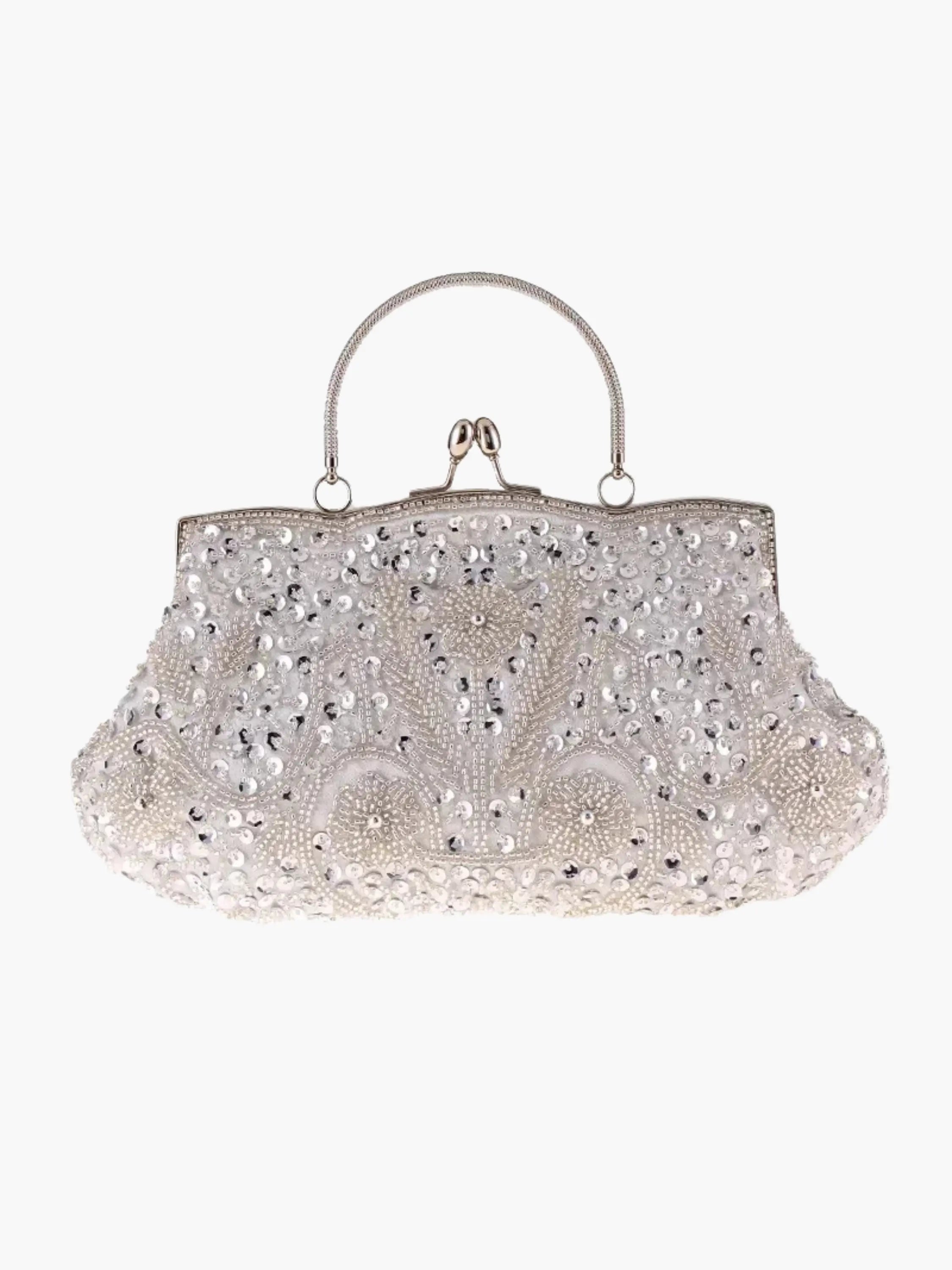 Hvid perlebesat håndtaske med vintage design, metalhåndtag og dekorative mønstre. Elegant accessory til bryllup eller fest.