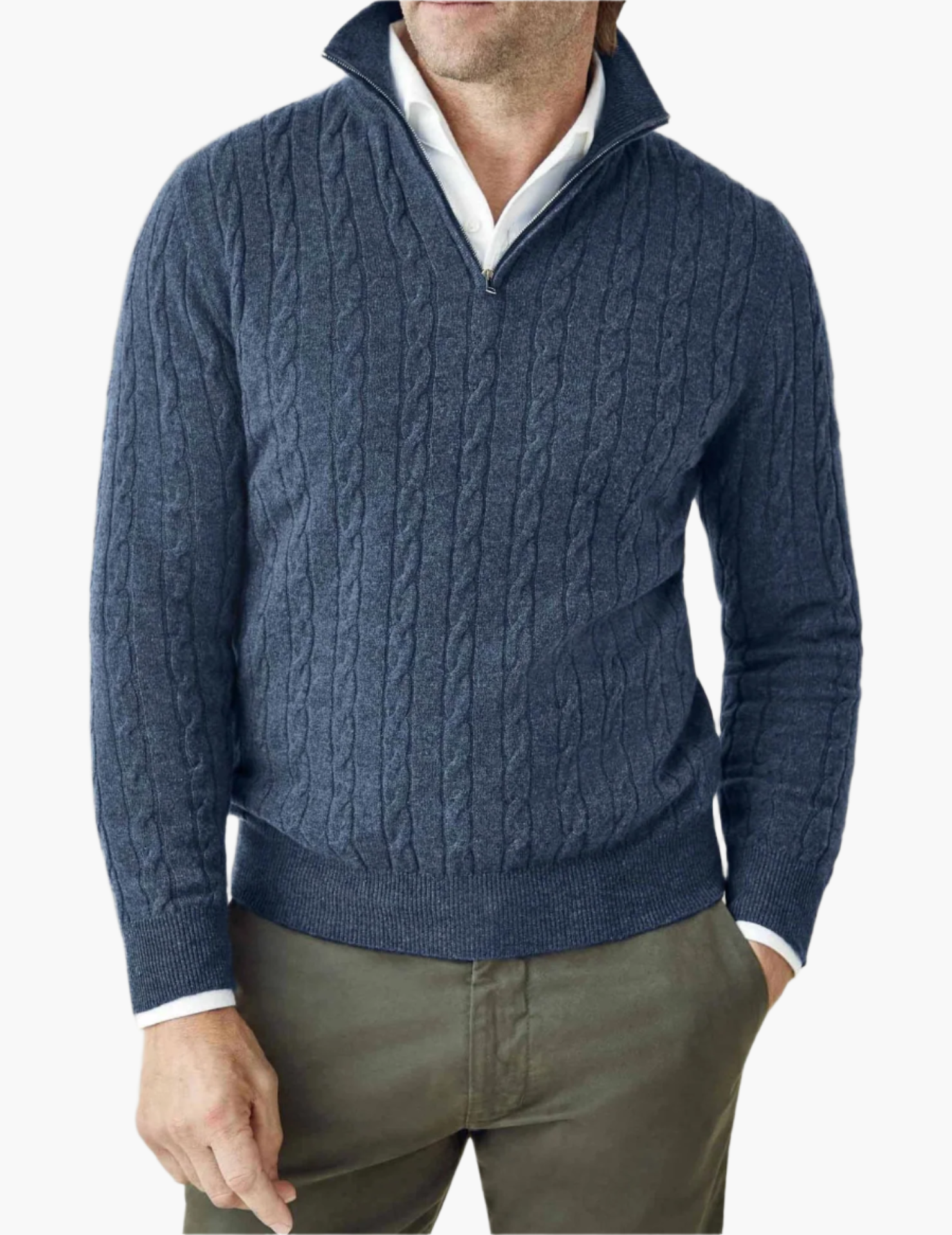 Mand iført blå kabelstrikket sweater med lynlås og hvid skjorte, kombineret med olivengrønne bukser. Elegant herremode, efterårslook.