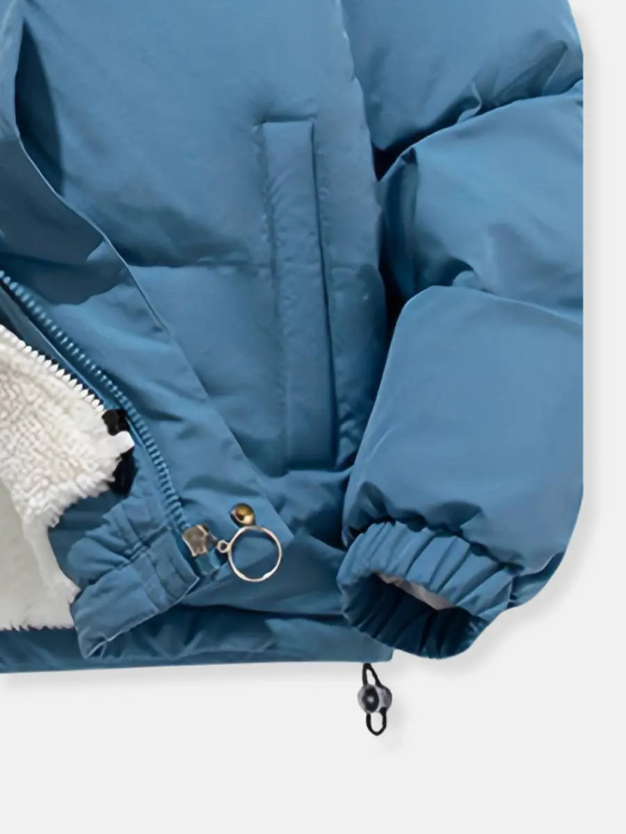 Blå vinterjakke med lynlås, pelsfor og elastiske manchetter. Ideel til koldt vejr. Komfortabel og stilfuld jakke til vinterbrug.