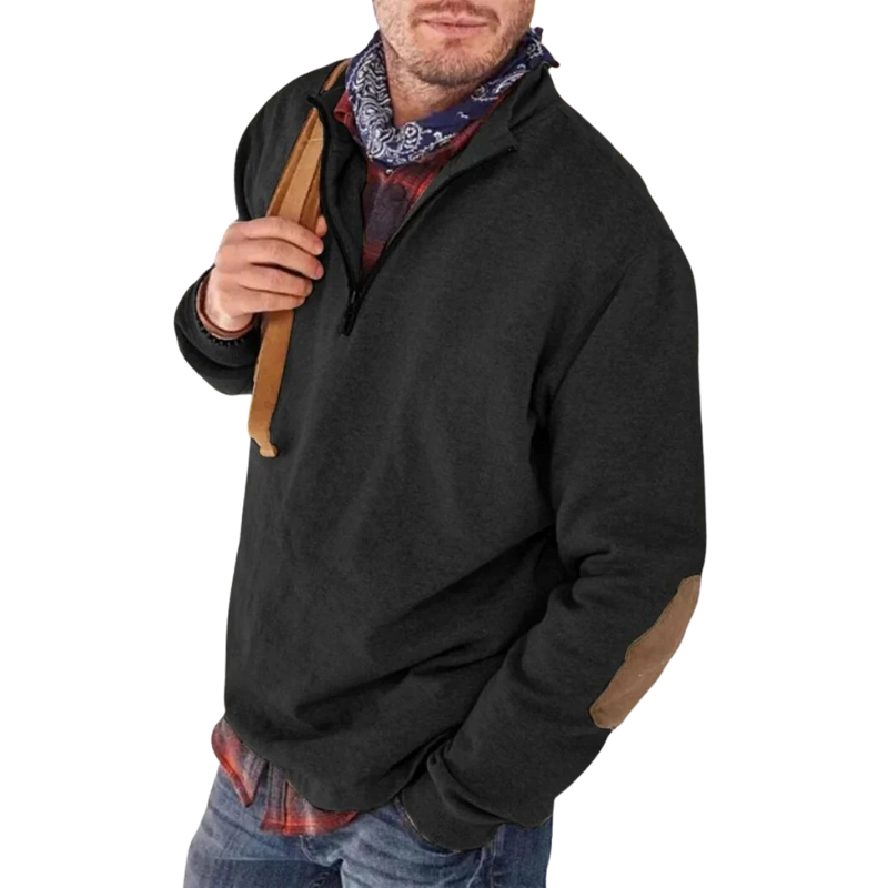 Mand iført sort fleecejakke med lynlås, brun albuelap og blå bandana. Perfekt til udendørs aktiviteter og casual mode. Komfortabel og stilfuld.