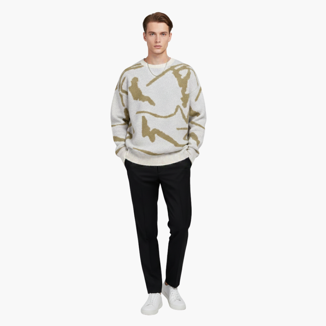 Ung mand iført hvid og beige camouflagemønstret sweater, sorte bukser og hvide sneakers. Moderne herremode, afslappet stil.