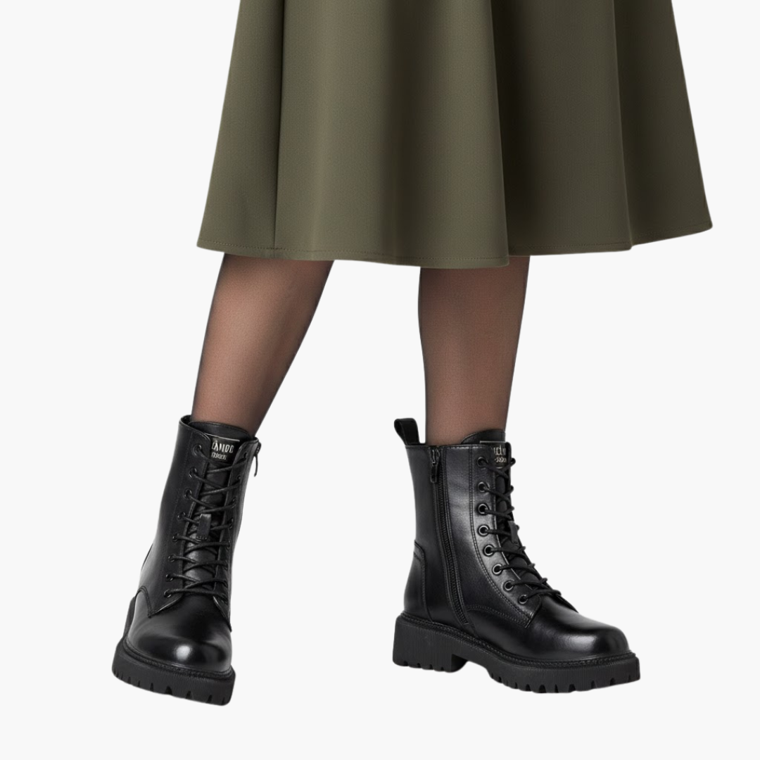 Sort læderstøvler med snørebånd og kraftig sål, båret af person i olivengrøn nederdel. Trendy fodtøj til efterår og vintermode.