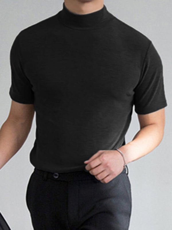 Mand iført sort turtleneck t-shirt og sorte bukser, moderne herremode, minimalistisk stil, elegant og stilfuldt outfit til mænd.