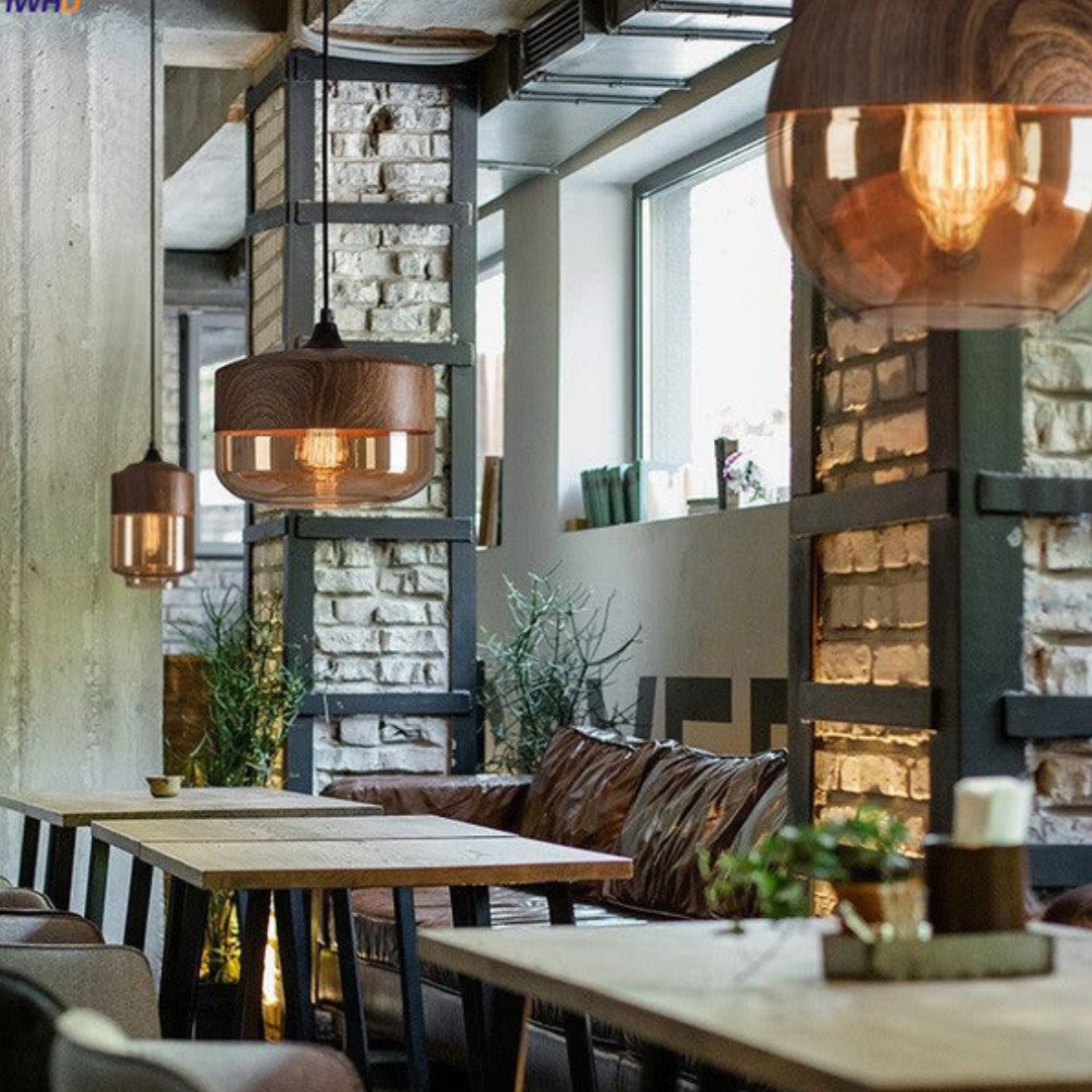 Moderne caféinteriør med træborde, industrielle lamper og murstensvægge. Hyggelig atmosfære med naturligt lys og stilfuld indretning.