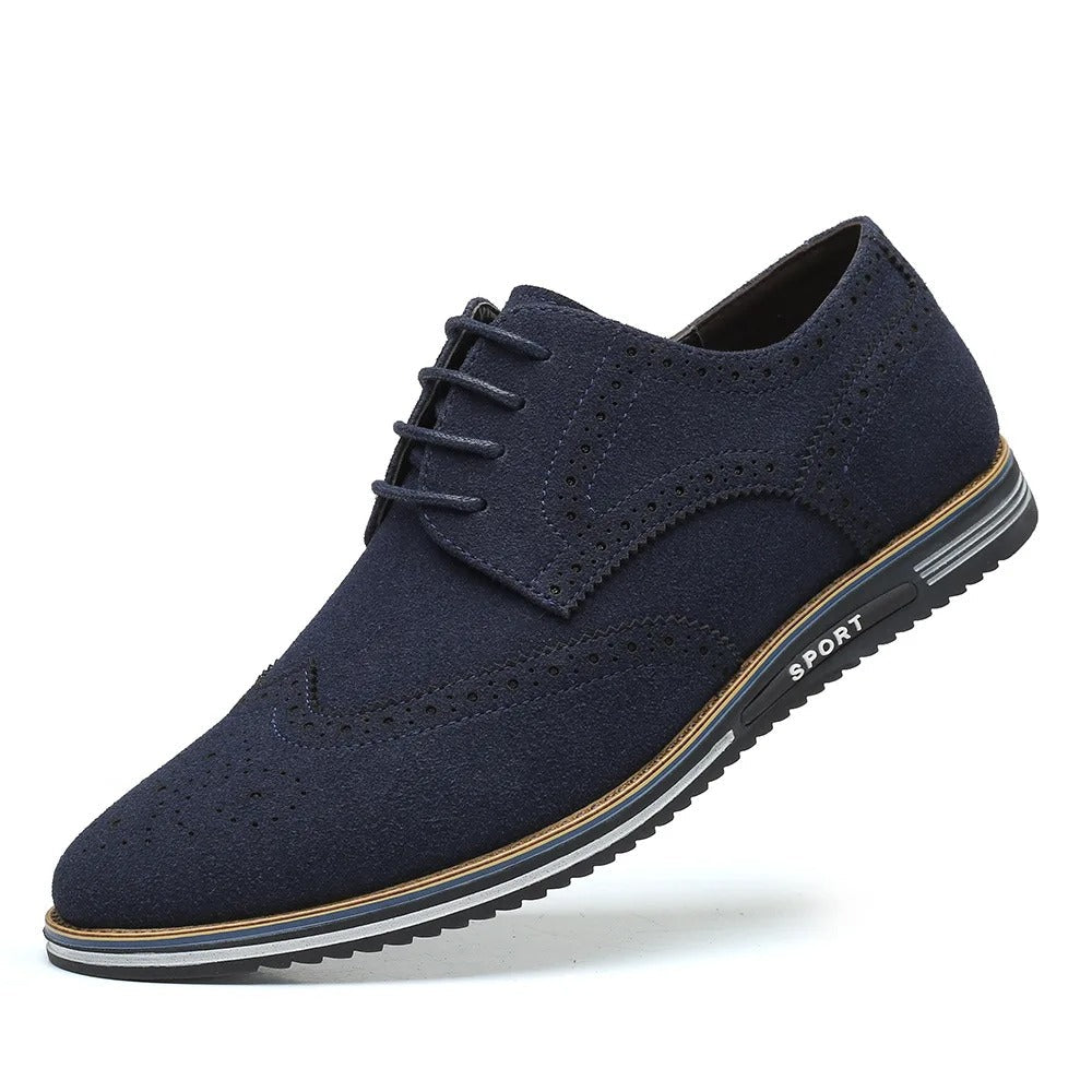 Mørkeblå herresko i ruskind med snørebånd og brogue-detaljer, sporty sål. Elegant og moderne design til både formelle og afslappede lejligheder.