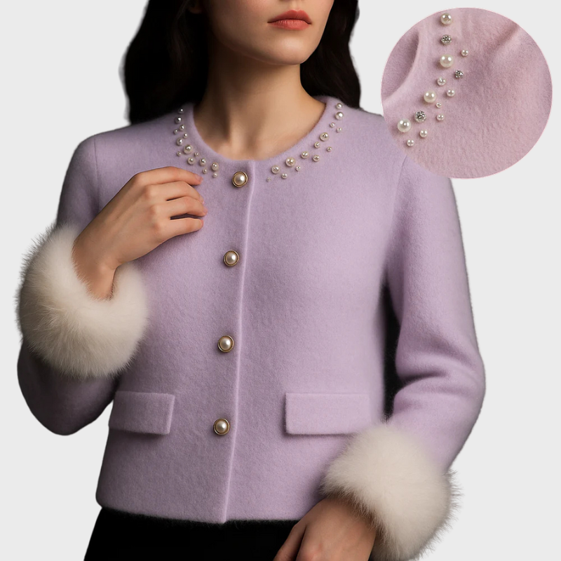 Kvinde iført lilla uldjakke med perleknapper og pelsmanchetter, nærbillede af perledetaljer. Elegant vintermode, luksuriøs jakke til kvinder.