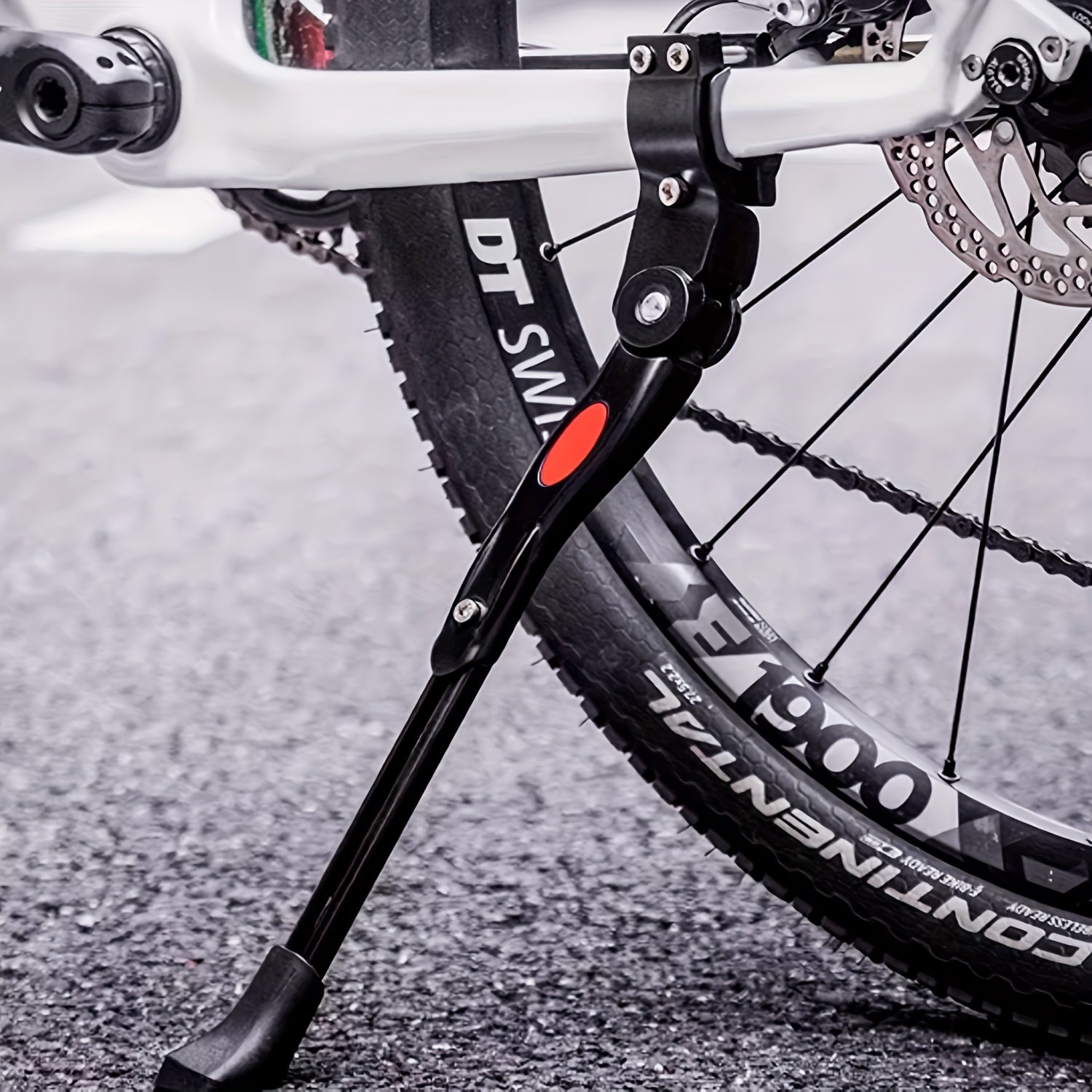 Cykelstøtteben på mountainbike med DT Swiss hjul og Schwalbe dæk, parkeret på asfalt. Robust cykeltilbehør til terræn og bykørsel.