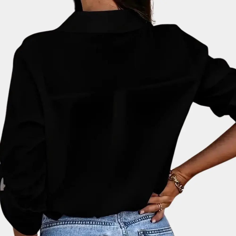 Sort skjorte til kvinder set bagfra, med lange ærmer og klassisk krave, kombineret med blå jeans. Stilfuldt og moderne tøj til hverdagsbrug.