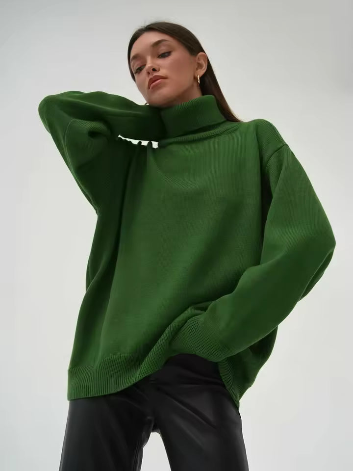 Ung kvinde iført en grøn oversized sweater og sorte læderbukser. Moderne mode, afslappet stil, minimalistisk look, trendy vintertøj.