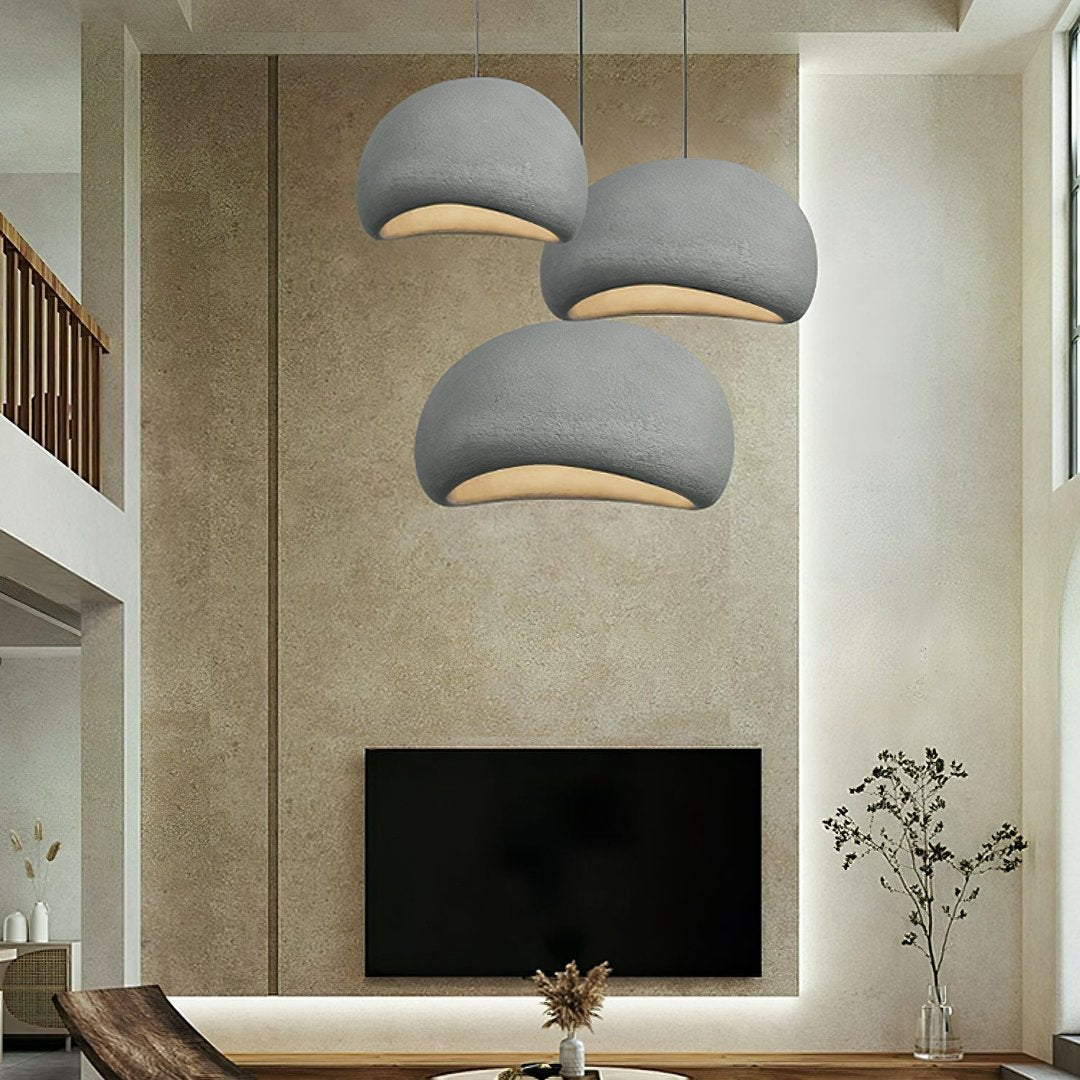 Moderne stue med tre grå, kuppelformede loftslamper, minimalistisk indretning, fladskærms-TV og dekorative planter. Skandinavisk design.