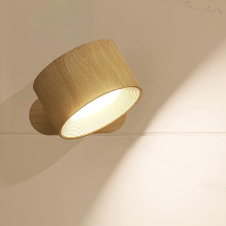 Moderne væglampe i træ med rund skærm, der udsender varmt lys. Stilfuldt design, ideel til indretning og belysning i hjemmet.