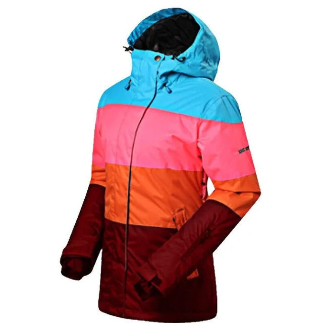 Farverig vinterjakke til kvinder med hætte, vandtæt og vindtæt, i blå, pink, orange og rød. Perfekt til udendørs aktiviteter og skiture.