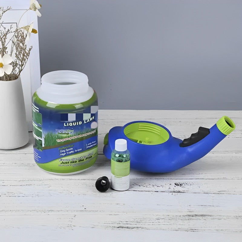 Blå og grøn flydende græsplæne sprøjte med tilhørende flaske og beholder på hvidt træbord, ideel til nem græspleje og vedligeholdelse.