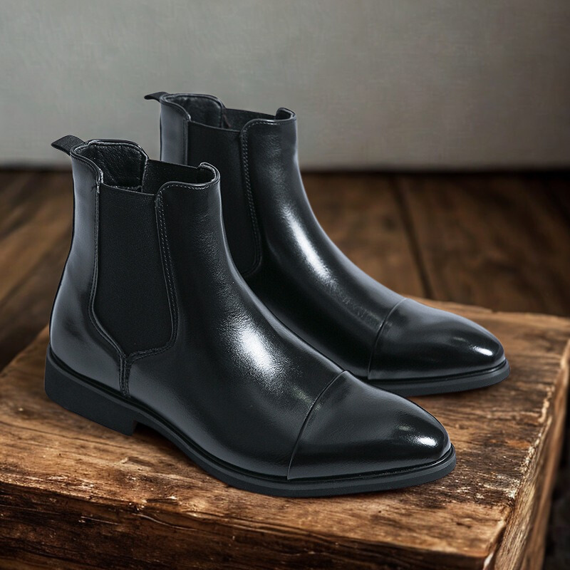 Sort læderstøvle på træbord, elegant design, herrestøvle, Chelsea-stil, glat finish, modefodtøj, klassisk og stilfuldt valg til mænd.