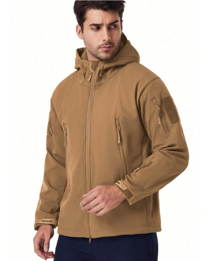Mand iført brun softshell-jakke med hætte, lynlåse og lommer. Jakken er velegnet til udendørsaktiviteter. Komfortabel og funktionel beklædning.