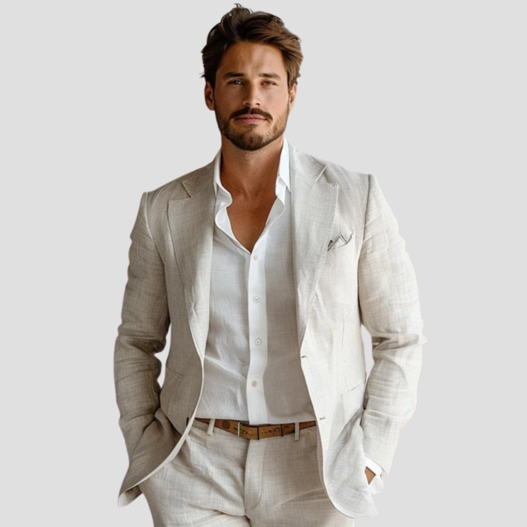 Jeg ved ikke, hvem personen er, men billedet viser en mand i en lys jakkesæt og hvid skjorte. Han har hænderne i lommerne og ser direkte fremad.