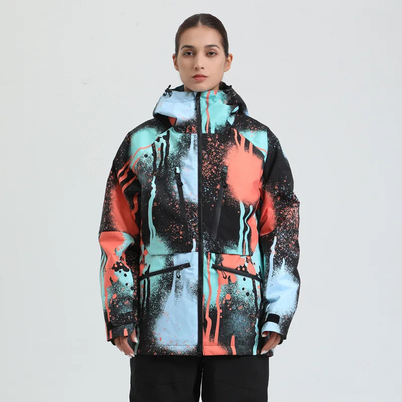 Kvinde iført farverig, abstrakt mønstret vinterjakke med hætte. Jakken har sorte, røde og blå nuancer, ideel til moderne vintermode.