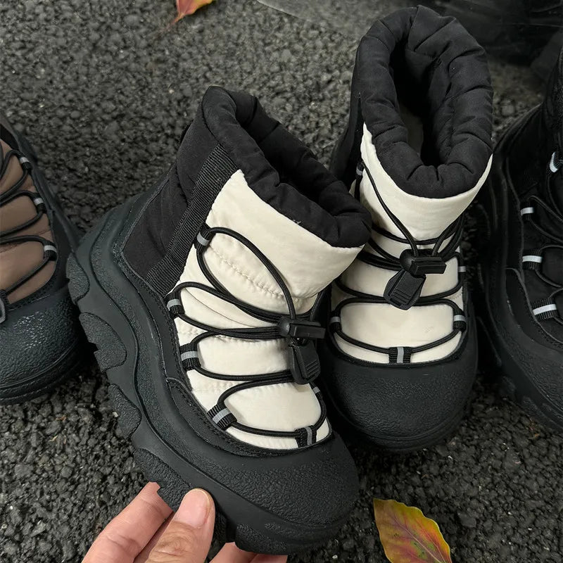 Sort og hvid vinterstøvle med tyk sål og snørebånd på grusvej. Komfortabelt og stilfuldt fodtøj til koldt vejr.