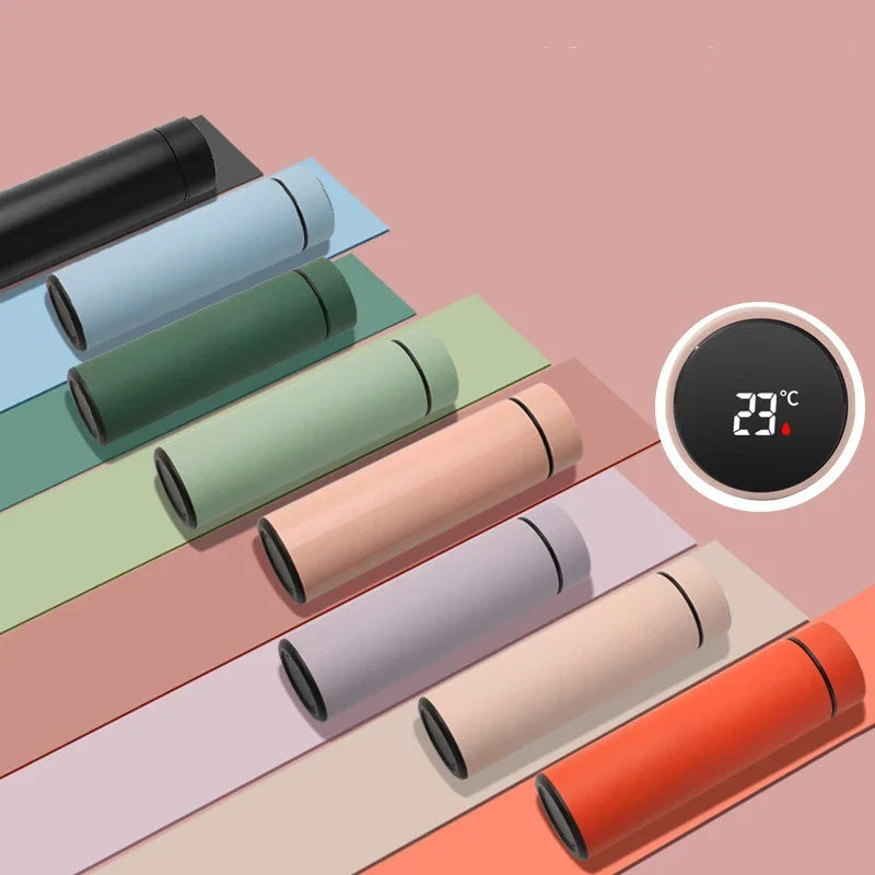 Farverige termoflasker med digital temperaturvisning på lyserød baggrund. Moderne design, isolerede flasker, perfekt til varme drikke.