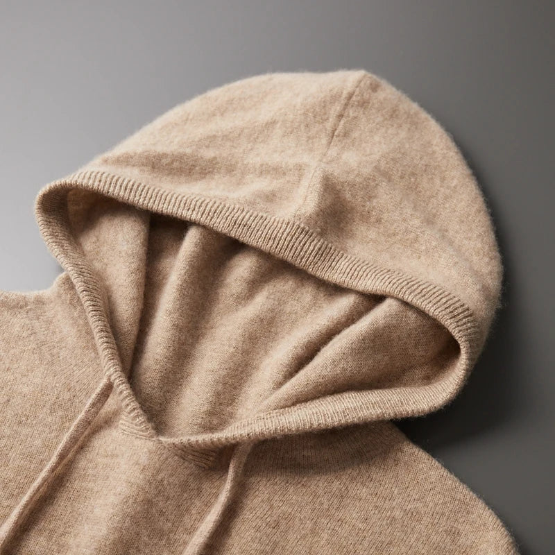 Beige cashmere hættetrøje på grå baggrund, blød og luksuriøs tekstur, perfekt til vintermode. Høj kvalitet, komfortabelt design.