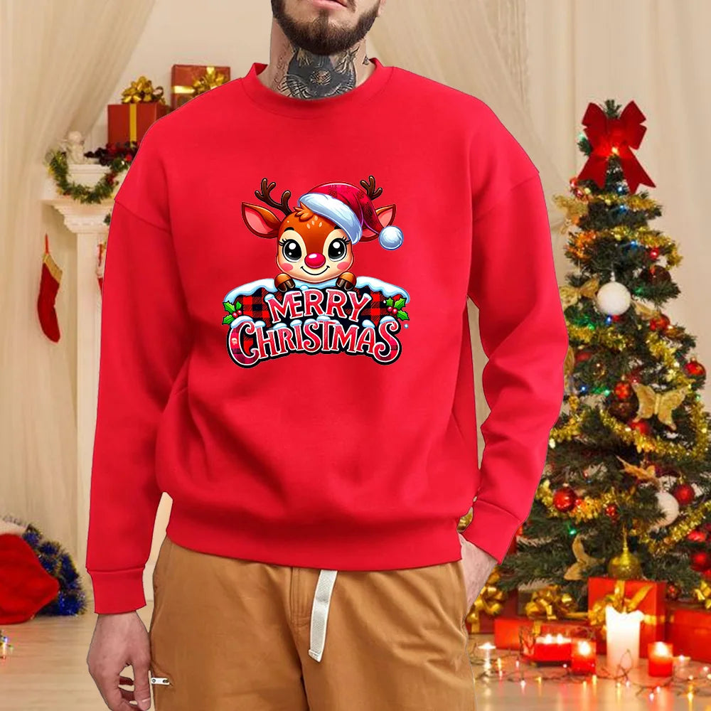 Rød juletrøje med tegneserie-rensdyr og "Merry Christmas" tekst, mand iført trøjen i julepyntet stue med juletræ i baggrunden.