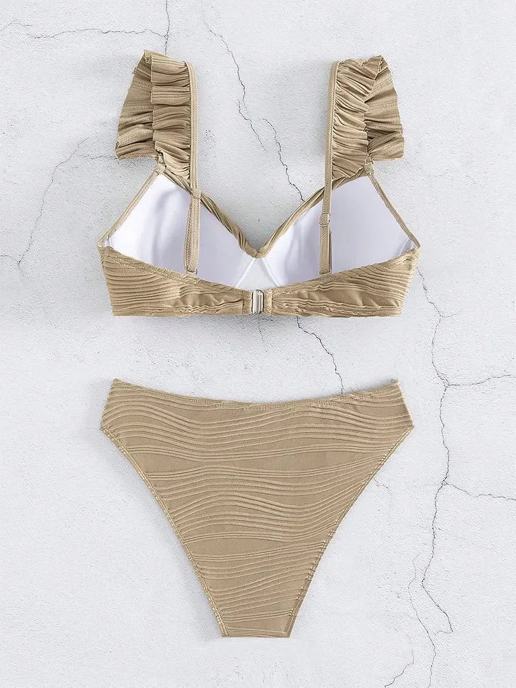 Beige bikini med flæsedetaljer, to-delt sæt på lys baggrund. Moderne badetøj, sommermode, strandtøj, kvinders badedragt.