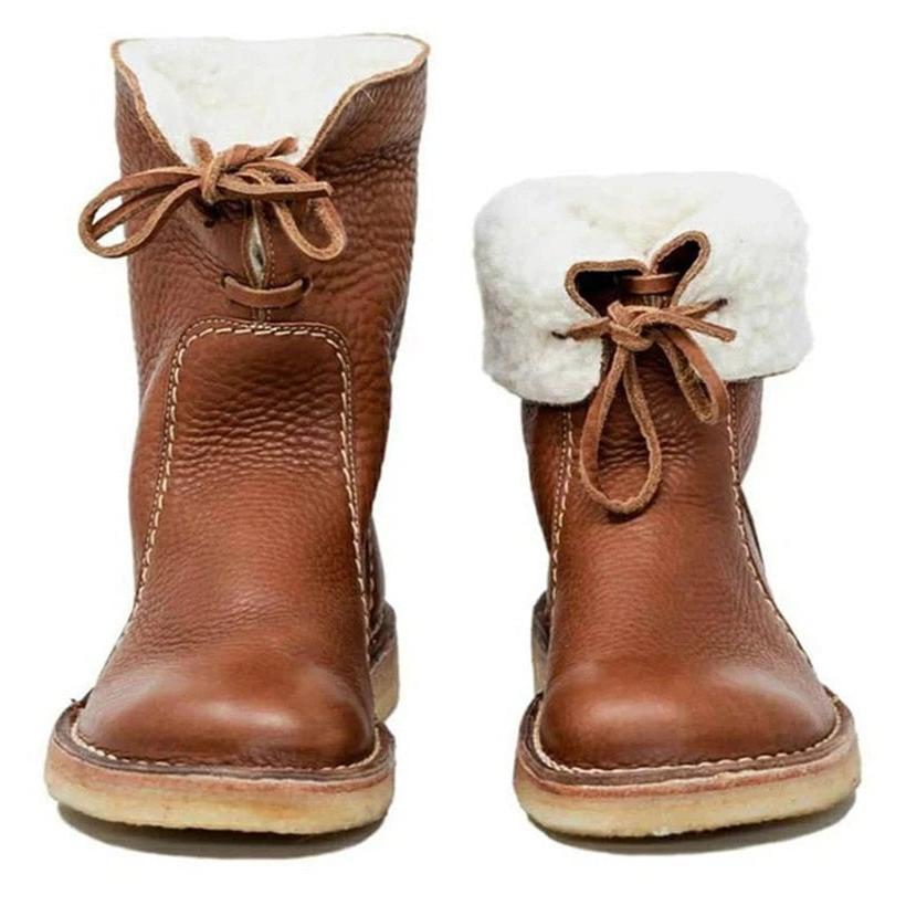 Brune læderstøvler med hvidt pelsfor, snørebånd og synlige stikninger. Komfortable vinterstøvler til kvinder. Trendy fodtøj til koldt vejr.