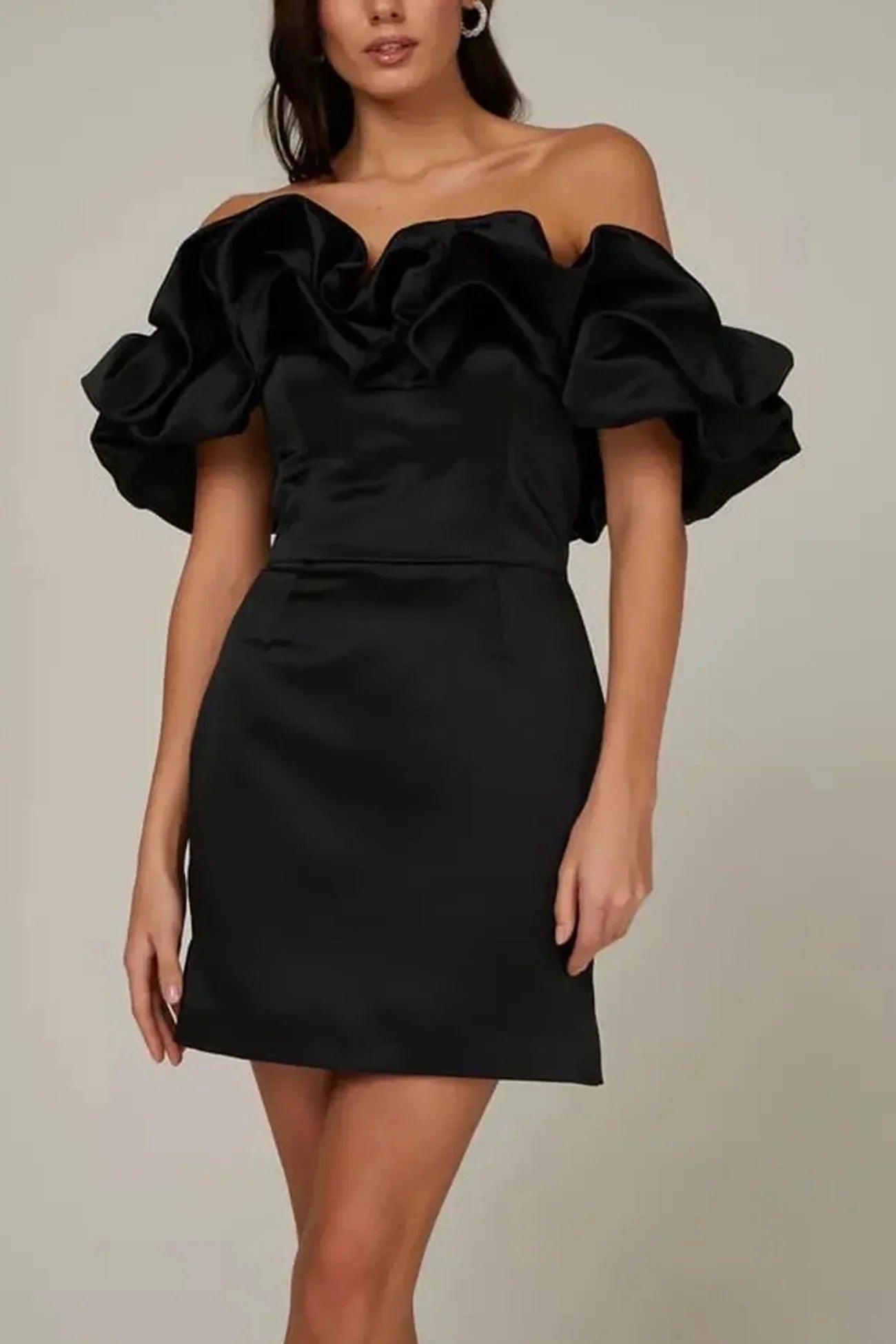 Sort cocktailkjole med off-shoulder design og voluminøse ærmer. Elegant og stilfuld kjole til festlige lejligheder.