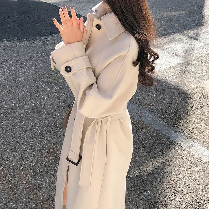 Kvinde i beige trenchcoat på solrig gade, elegant mode, efterårsjakke, stilfuldt design, udendørs tøj, moderne kvindetøj, klassisk frakke.