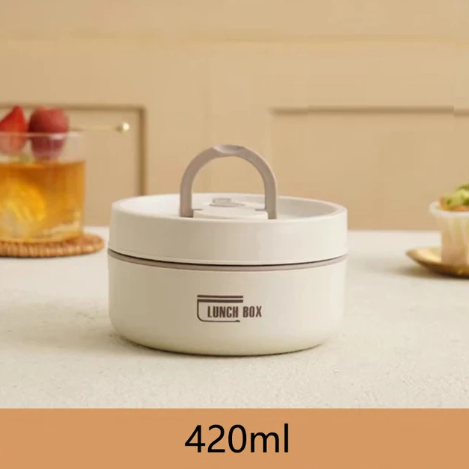 Hvid rund madkasse med håndtag, kapacitet 420 ml, på beige bord. Perfekt til opbevaring af frokost. Ideel til skole eller arbejde.