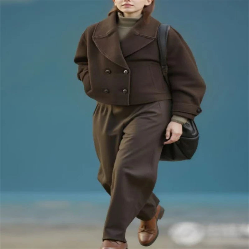 Kvinde iført brun uldfrakke og bukser, bærer sort taske. Mode, vintertøj, stilfuldt outfit, moderne kvindemode, elegant påklædning.