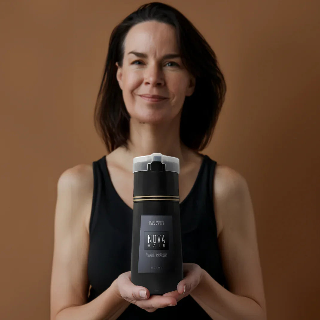 Kvinde i sort top holder en flaske Nova hårplejeprodukt mod brun baggrund. Hårpleje, skønhed, kvinde, Nova, flaske, plejeprodukt.