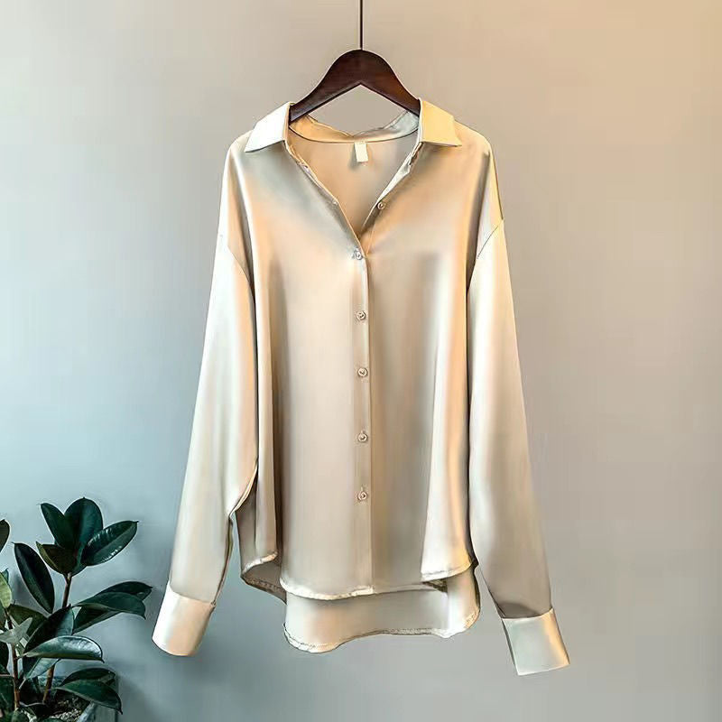 Beige silkeskjorte på bøjle, elegant design med knaplukning og lange ærmer, perfekt til stilfulde outfits.