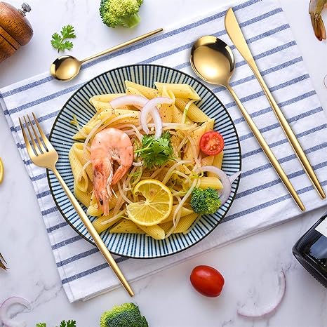 Pastaret med rejer, citron, cherrytomat og broccoli på stribet dug. Guld bestik ved siden af. Perfekt til italiensk madlavning og opskrifter.