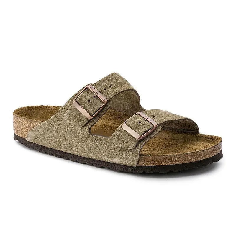 Beige Birkenstock sandal med to justerbare remme og korksål, komfortabel fodtøj til mænd og kvinder, populær sommersandal i klassisk design.