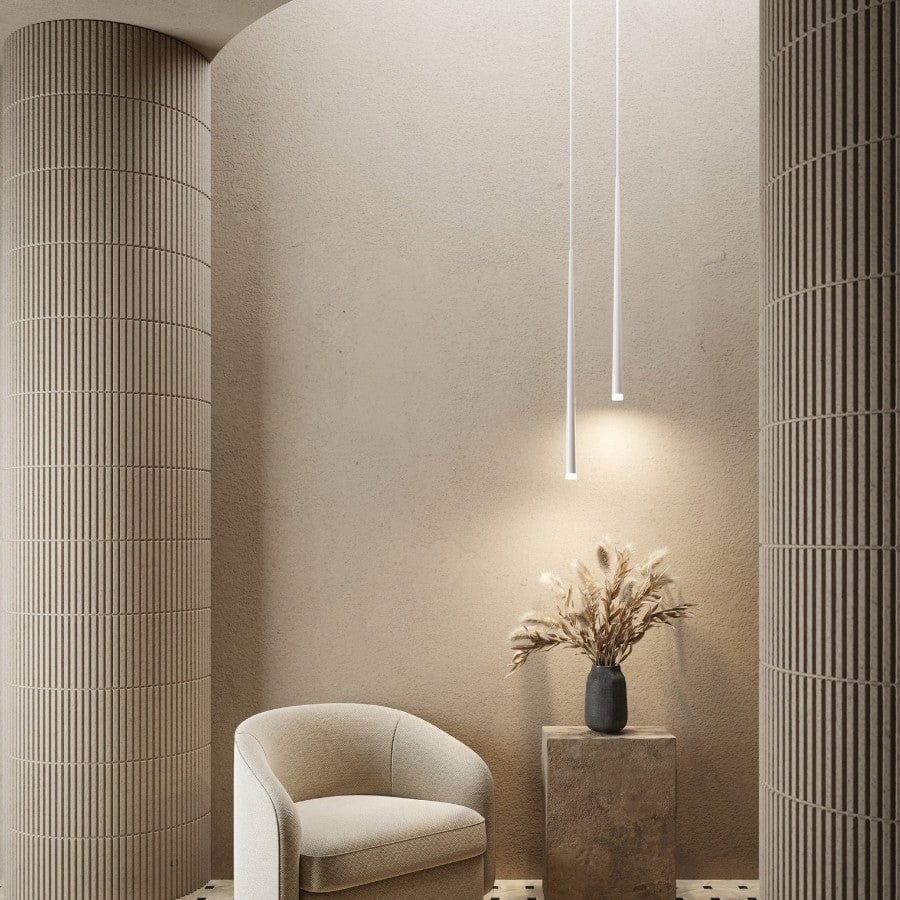 Moderne minimalistisk interiør med beige lænestol, dekorativ vase med tørrede blomster på piedestal og slanke hængelamper. Skandinavisk design.