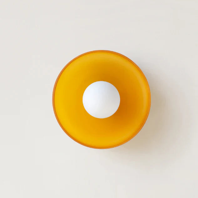 Orange skål med hvid kugle i midten, minimalistisk design, set ovenfra. Moderne boligindretning, skandinavisk stil, enkelhed, æstetik.