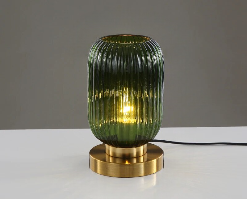 Grøn glasbordlampe med rillet design og gylden base, moderne belysning, stilfuldt interiør, dekorativ lampe til stue eller soveværelse.