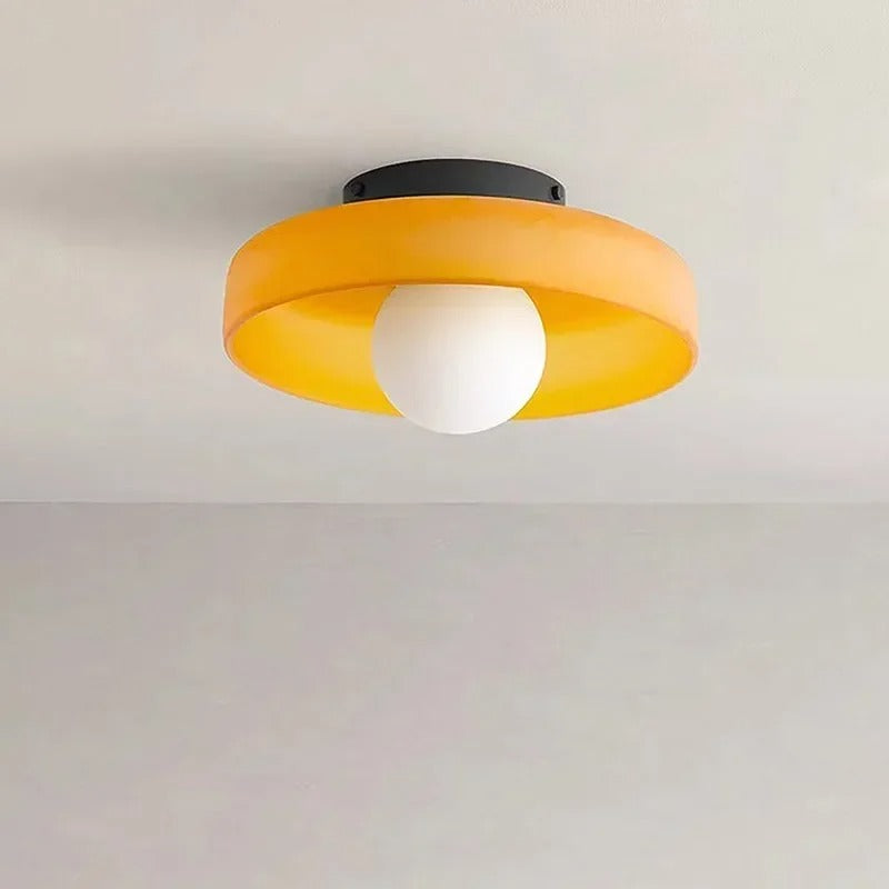 Moderne loftlampe med rund, orange skærm og hvid pære. Stilfuldt design til stue eller køkken. Energibesparende belysning.