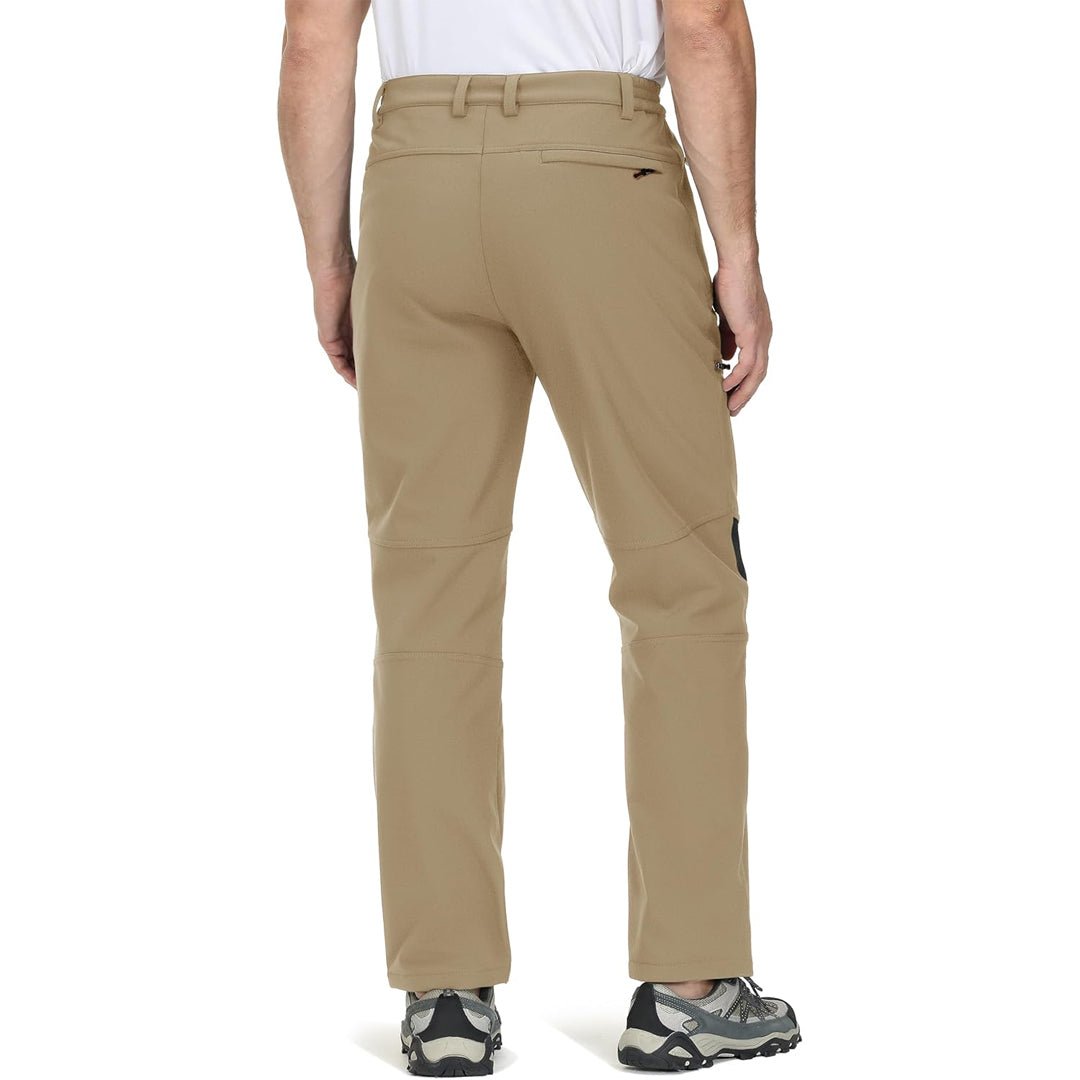 Mand iført beige vandrebukser og grå vandresko set bagfra. Outdoor tøj, komfortable bukser til vandring, fritidstøj til mænd.