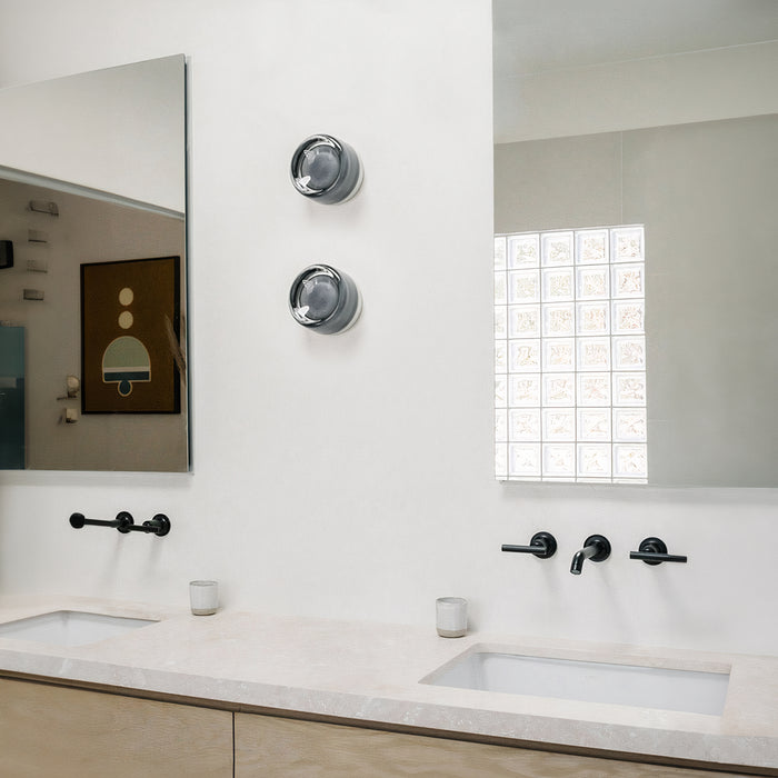 Moderne badeværelse med dobbelt håndvask, sorte armaturer, stort spejl og minimalistisk indretning. Elegant design med kunst på væggen.