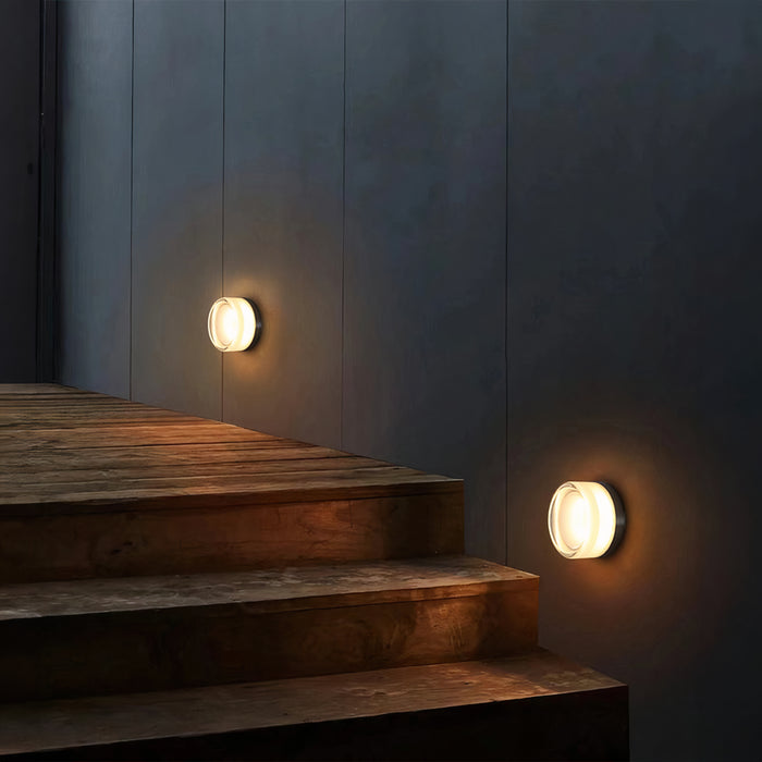 Væglamper lyser en moderne trappe op i mørket. Stilfuld belysning, minimalistisk design, udendørs væglampe, energibesparende LED.