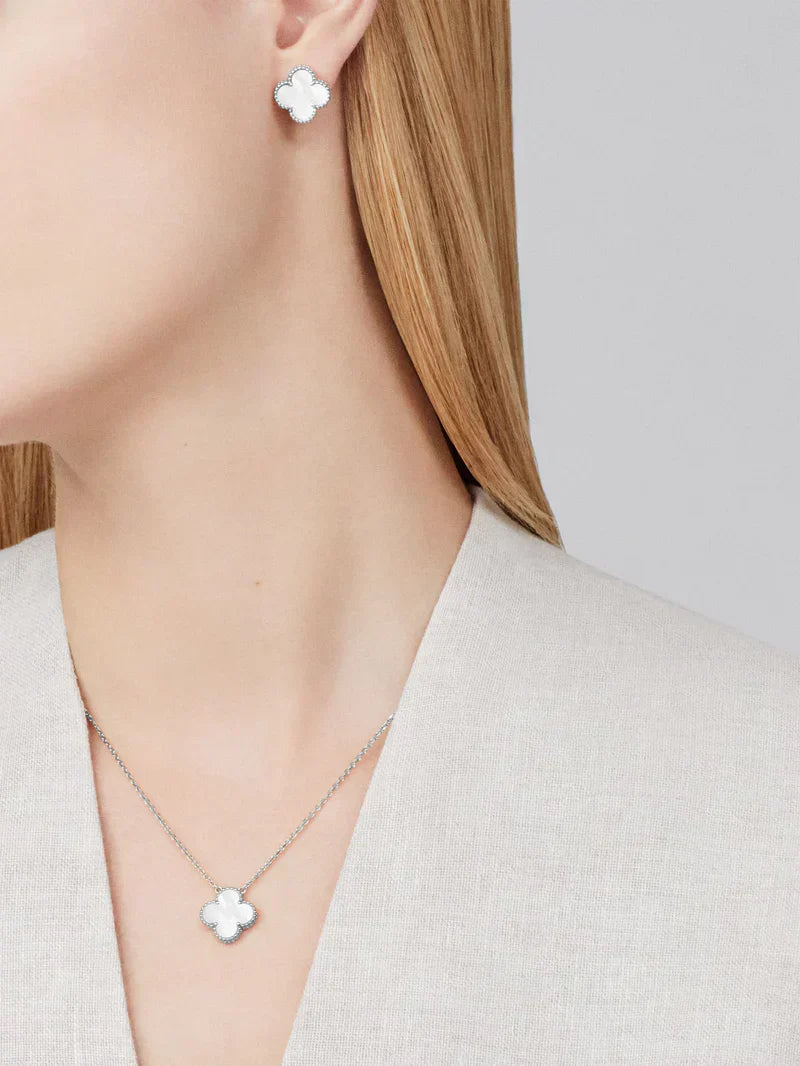 Kvindelig model med Van Cleef & Arpels Alhambra øreringe og halskæde i hvidguld og perlemor, elegant smykkesæt, luksusmode.