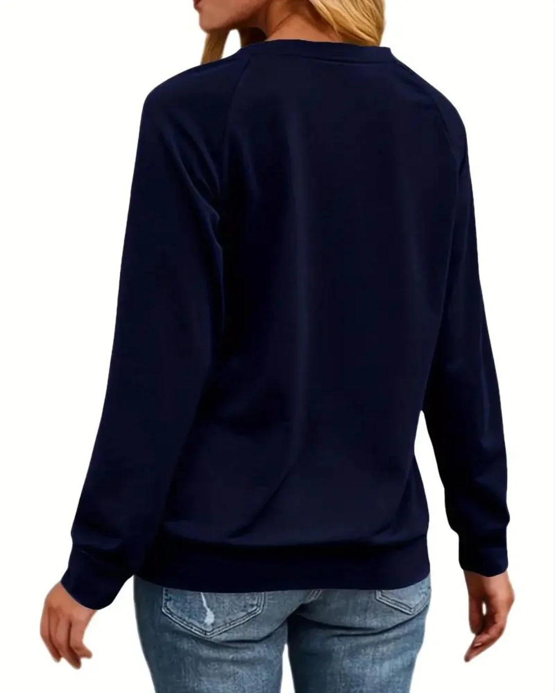 Kvinde iført mørkeblå sweatshirt og lyseblå jeans, set bagfra. Casual mode, komfortabelt tøj, afslappet stil.