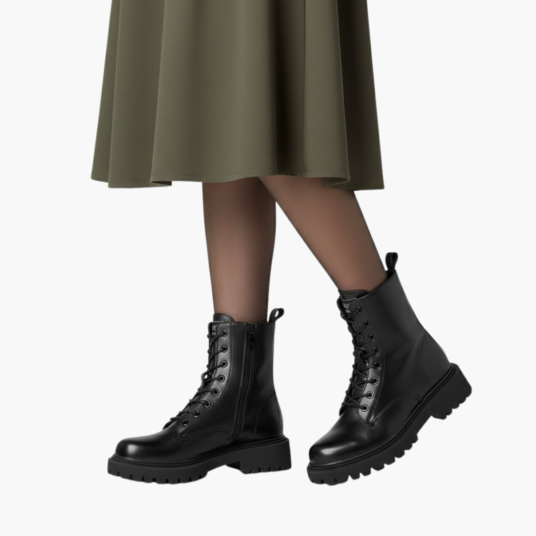 Sort læderstøvle med snørebånd og lynlås, robust sål, bæres af person i olivengrøn nederdel. Trendy fodtøj til efterår og vintermode.