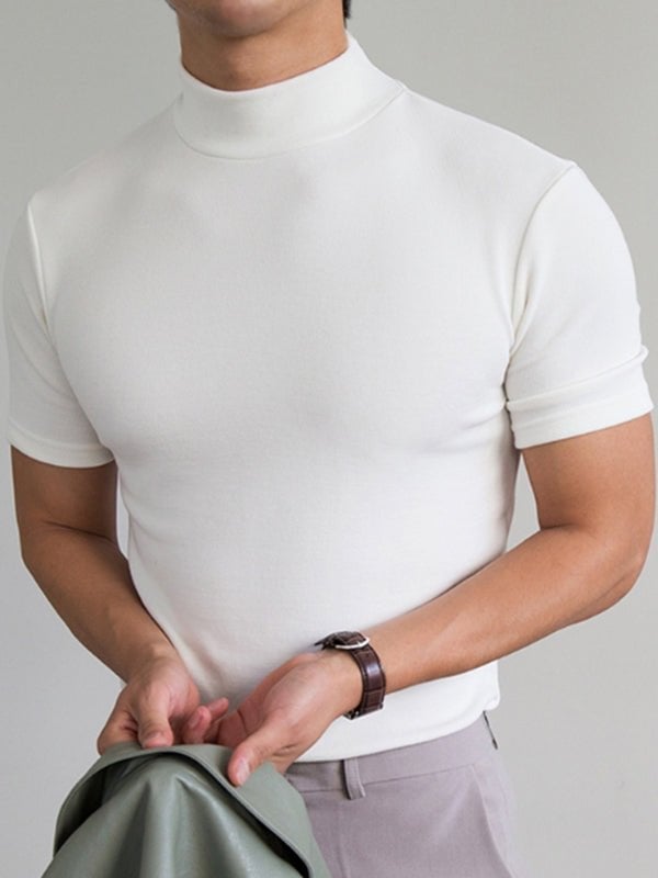 Hvid kortærmet turtleneck trøje til mænd, moderne minimalistisk design, bæres af mand med gråt jakkesæt, stilfuldt og elegant look.