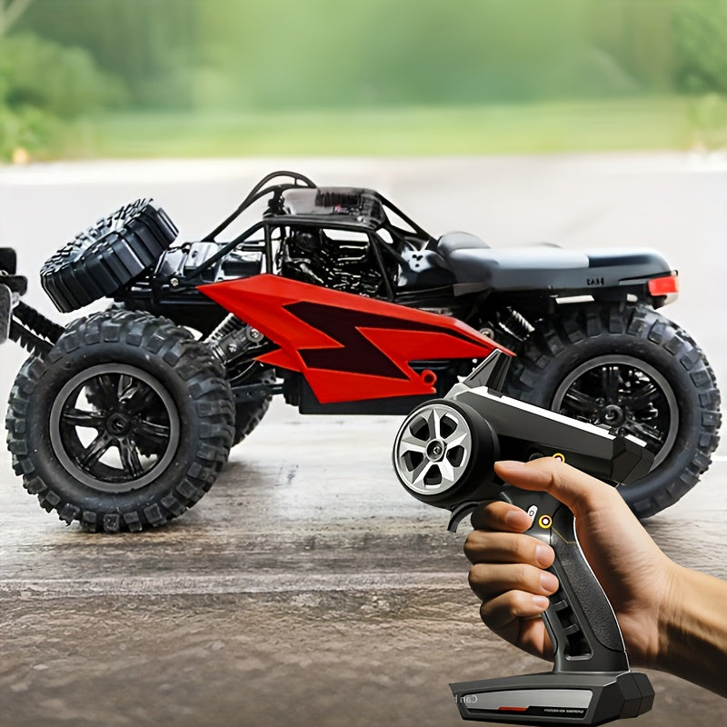 Fjernstyret off-road bil med store dæk og rød karrosseri, håndholdt controller i forgrunden. Perfekt til terrænkørsel og RC-entusiaster.